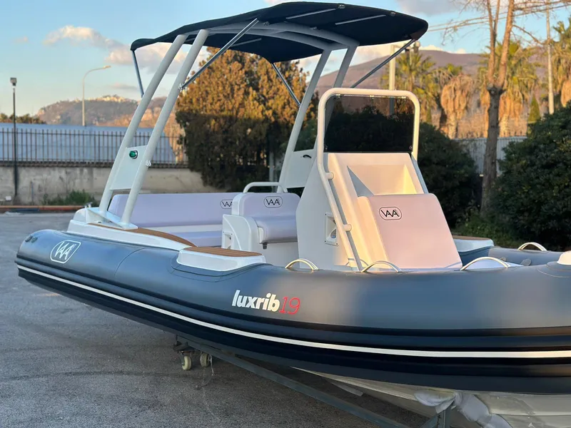 Slide: The Image of 2025 Aqvaboats luxrib 19 inflatable boat with canopy, docked on land. - 19