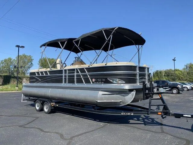 Slide: The Image of 2015 Silver Wave 250 Island SB Tri-Toon boat on a trailer in a parking lot. - 2