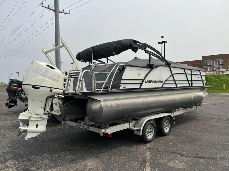 Slide: The Image of 2021 Berkshire 23 SB2 STS pontoon boat on a trailer with a Suzuki outboard motor. - 1
