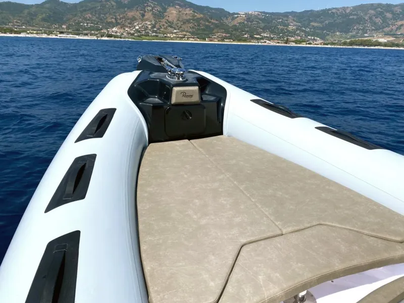 Slide: The Image of 2025 Ranieri CAYMAN 23 Sport boat on open water with scenic mountain backdrop. - 14
