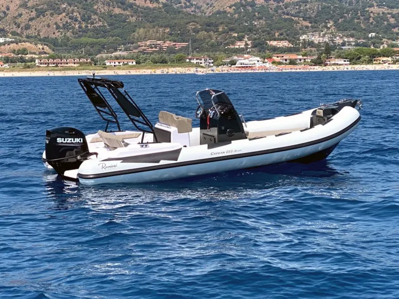 Slide: The Image of 2025 Ranieri CAYMAN 23 Sport boat on blue water with coastal background. - 2