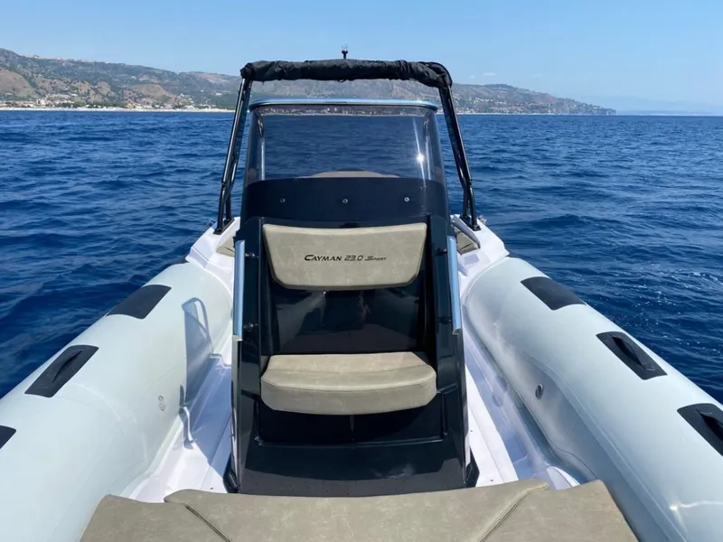 Slide: The Image of 2025 Ranieri CAYMAN 23 Sport boat on open water with coastal background. - 8