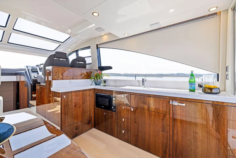 Slide: The Image of Luxurious interior of 2025 Fairline Targa 50 GT yacht with modern kitchen and panoramic windows. - 23