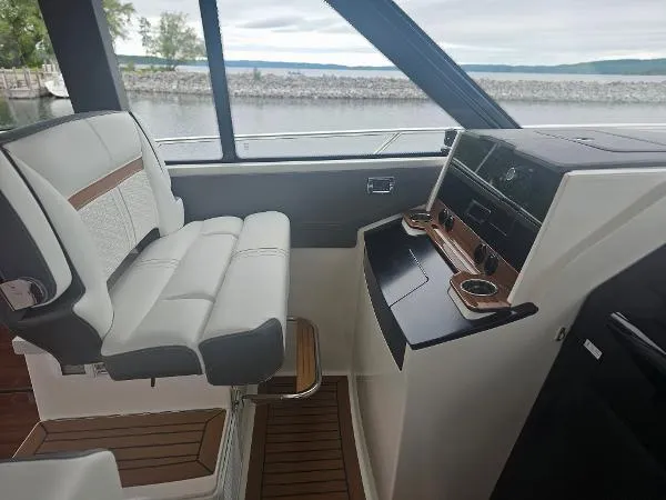 Slide: The Image of 2021 Tiara Sport 43 LE helm station with luxurious seating and modern controls. - 16