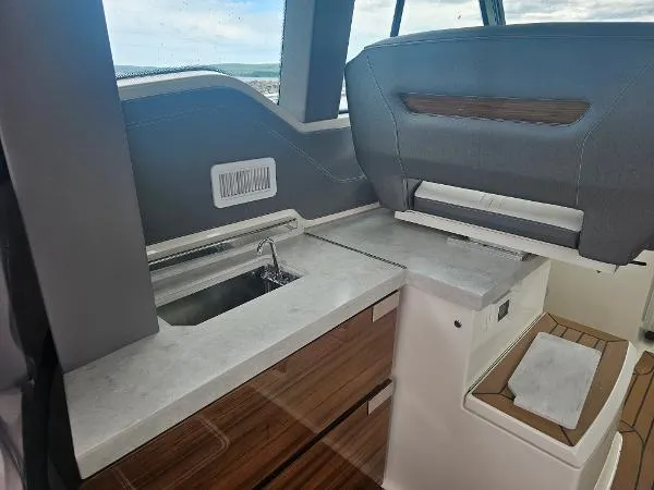 Slide: The Image of 2021 Tiara Sport 43 LE yacht interior with modern kitchenette and wood accents. - 20