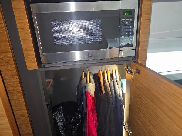 Slide: The Image of Microwave and closet space in 2021 Tiara Sport 43 LE boat. - 24