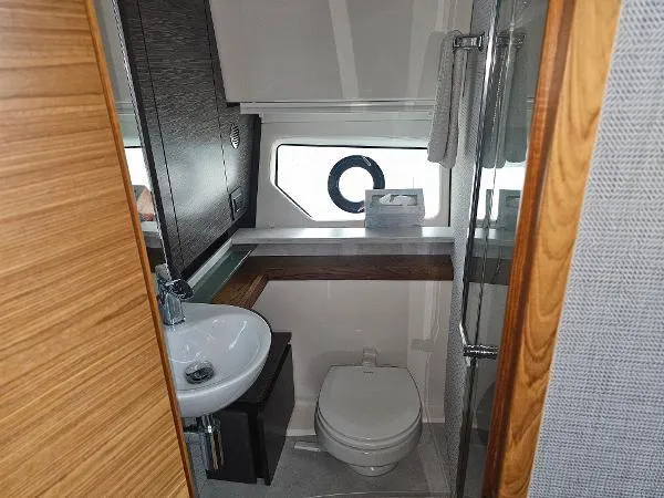 Slide: The Image of 2021 Tiara Sport 43 LE yacht bathroom with sink, toilet, and window. - 27