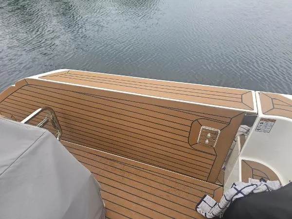 Slide: The Image of 2021 Tiara Sport 43 LE boat with teak deck at the stern, docked on calm water. - 29