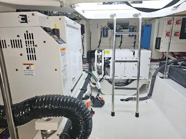 Slide: The Image of Engine room of a 2021 Tiara Sport 43 LE boat with various equipment and wiring. - 34