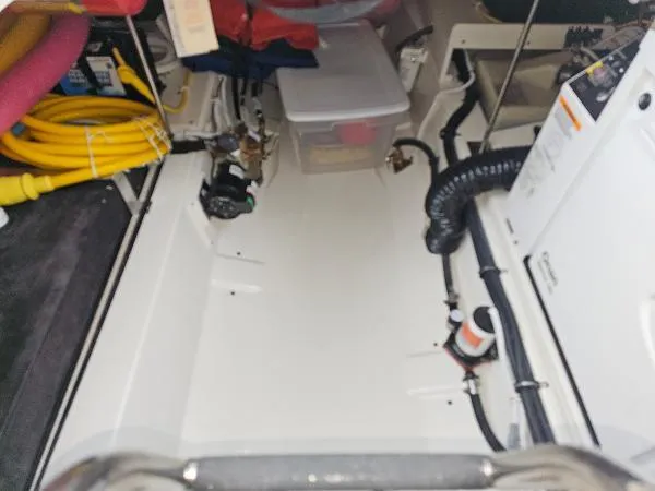 Slide: The Image of Engine compartment of a 2021 Tiara Sport 43 LE boat with various equipment and storage. - 35