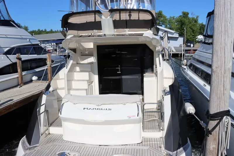 Slide: The Image of 2014 Marquis 42 Sport Bridge yacht docked at marina, rear view. - 11
