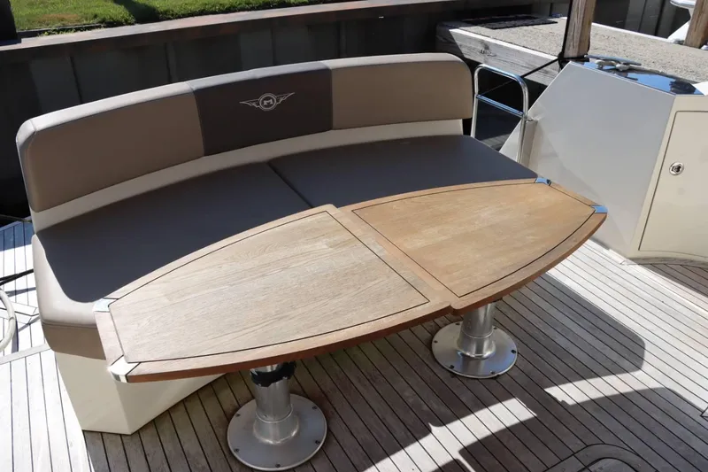 Slide: The Image of Marquis 42 Sport Bridge 2014 yacht seating area with wooden table and cushioned bench. - 16