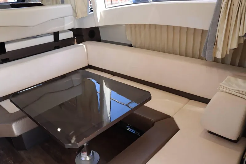 Slide: The Image of Interior seating area of 2014 Marquis 42 Sport Bridge yacht with a glossy table. - 20