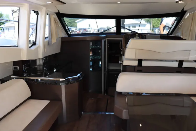 Slide: The Image of Interior of 2014 Marquis 42 Sport Bridge yacht with modern seating and kitchenette. - 21