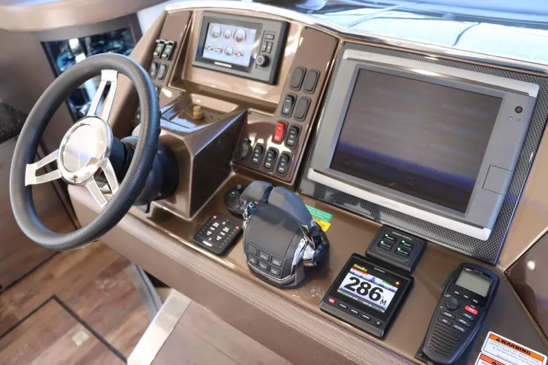 Slide: The Image of 2014 Marquis 42 Sport Bridge helm with steering wheel, navigation screens, and control panels. - 28