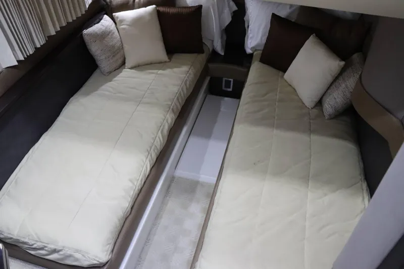 Slide: The Image of Twin beds in the 2014 Marquis 42 Sport Bridge cabin with beige bedding and pillows. - 29