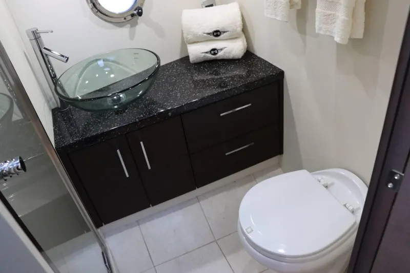Slide: The Image of Modern bathroom in 2014 Marquis 42 Sport Bridge yacht with glass sink and white toilet. - 32