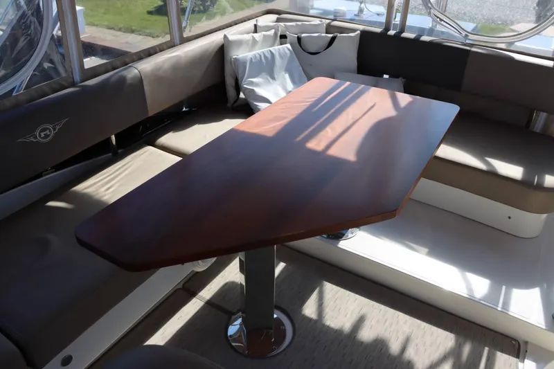 Slide: The Image of Interior seating area of 2014 Marquis 42 Sport Bridge yacht with wooden table. - 43