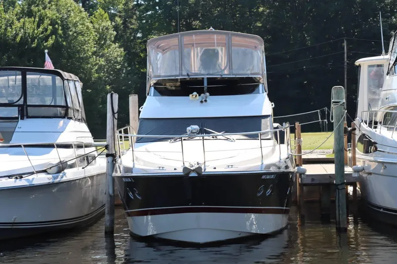 Slide: The Image of 2014 Marquis 42 Sport Bridge yacht docked between two boats. - 8