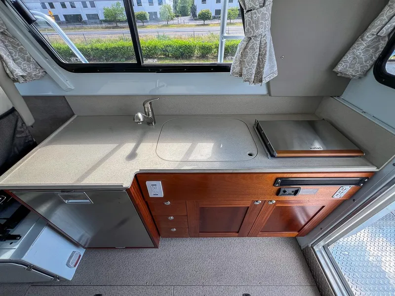 Slide: The Image of 2022 Hewescraft 290 Adventure boat kitchen with sink, stove, and storage cabinets. - 14