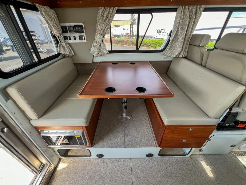 Slide: The Image of Interior of a 2022 Hewescraft 290 Adventure boat with a dining area and seating. - 15