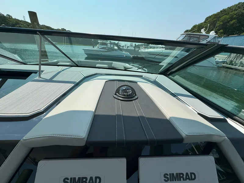 Slide: The Image of 2025 Cruisers Yachts 34 GLS Outboard dashboard with Simrad navigation, docked in marina. - 31