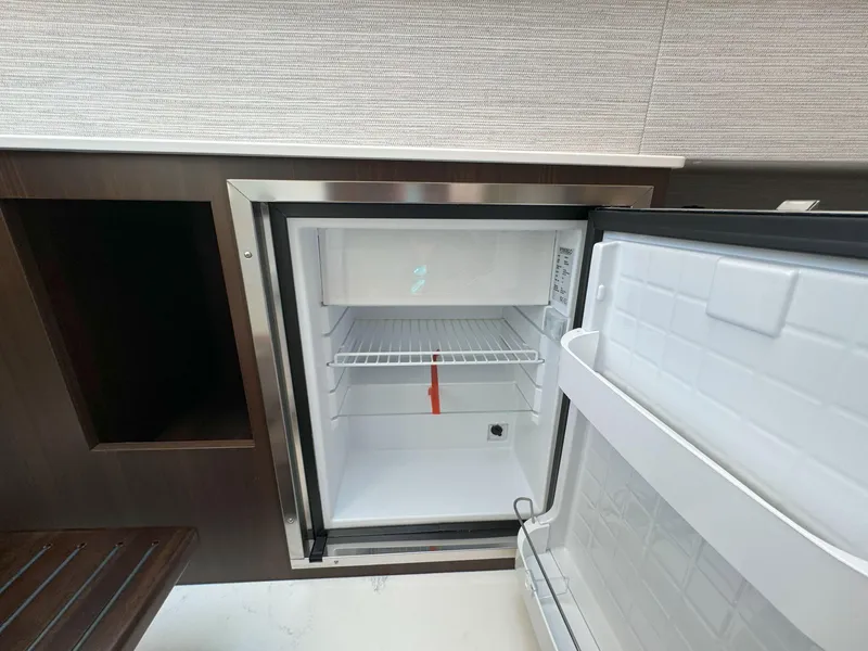 Slide: The Image of Open mini fridge inside 2025 Cruisers Yachts 34 GLS Outboard. - 40