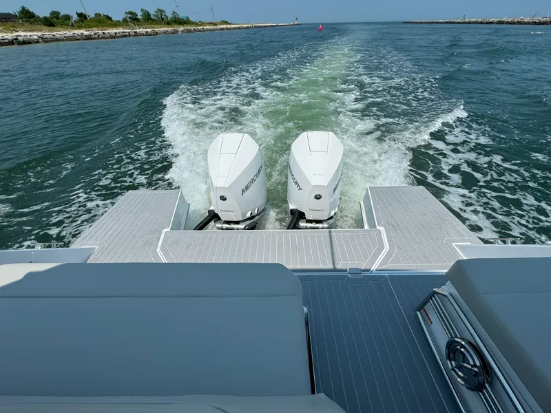 Slide: The Image of 2025 Cruisers Yachts 34 GLS Outboard cruising on open water, rear view of dual engines. - 15