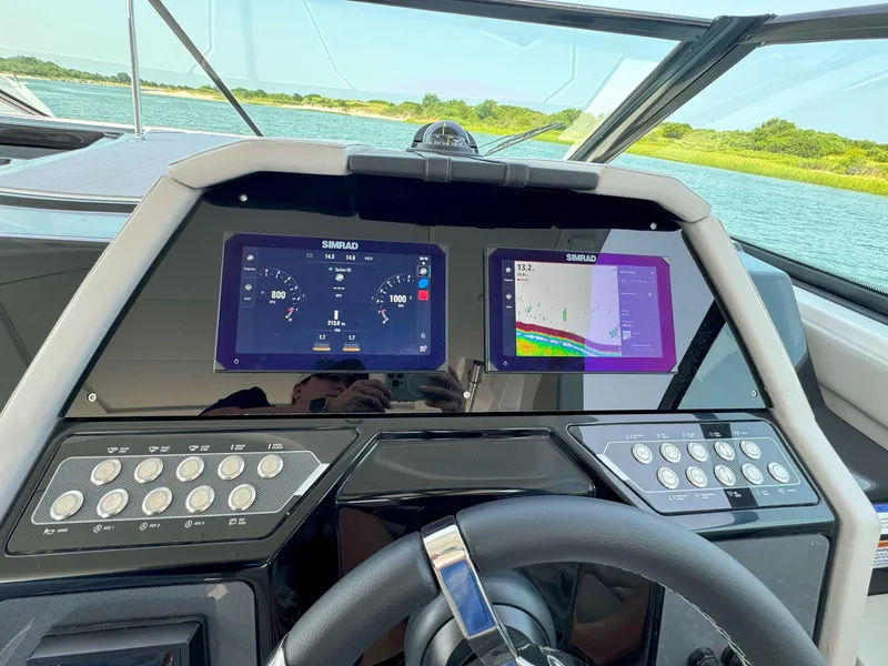 Slide: The Image of 2025 Cruisers Yachts 34 GLS Outboard dashboard with dual Simrad displays and control panel. - 29