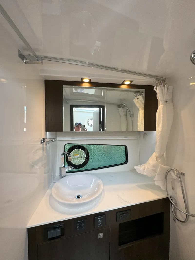 Slide: The Image of 2025 Cruisers Yachts 34 GLS Outboard bathroom with modern sink and mirror. - 48
