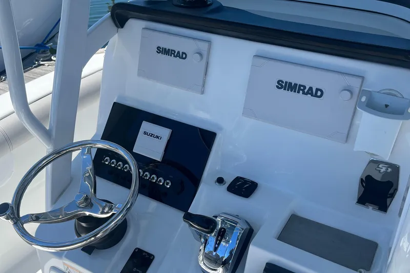 Slide: The Image of 2019 Sea Pro 239 Center Console boat dashboard with Simrad electronics and Suzuki controls. - 10