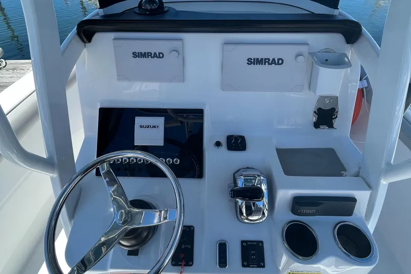 Slide: The Image of 2019 Sea Pro 239 Center Console boat dashboard with Simrad electronics and Suzuki controls. - 11