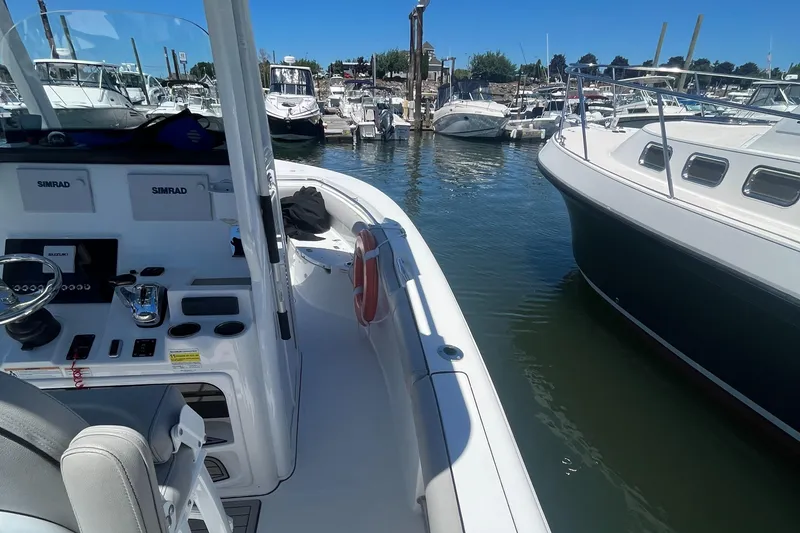 Slide: The Image of 2019 Sea Pro 239 Center Console boat docked at a marina with other boats. - 23