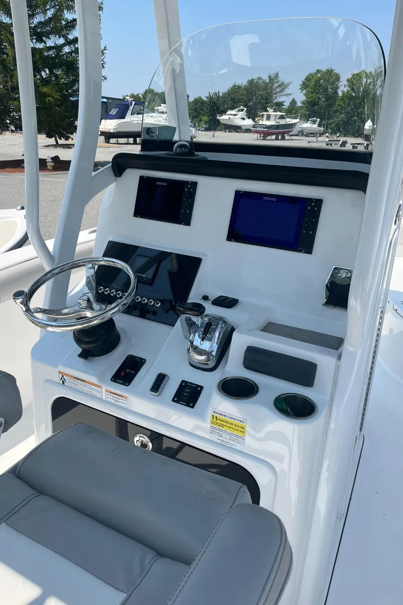 Slide: The Image of 2019 Sea Pro 239 Center Console boat dashboard with steering wheel and navigation screens. - 40