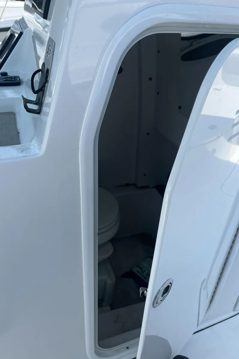 Slide: The Image of 2019 Sea Pro 239 Center Console boat interior with open door and visible toilet. - 41