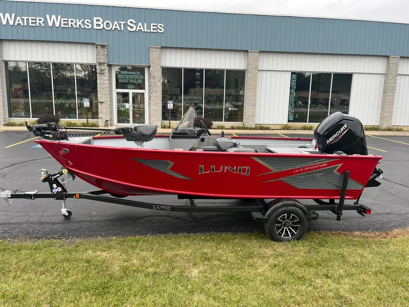 Slide: The Image of 2025 Lund 1675 Adventure SS boat in red, parked outside Water Werks Boat Sales. - 0