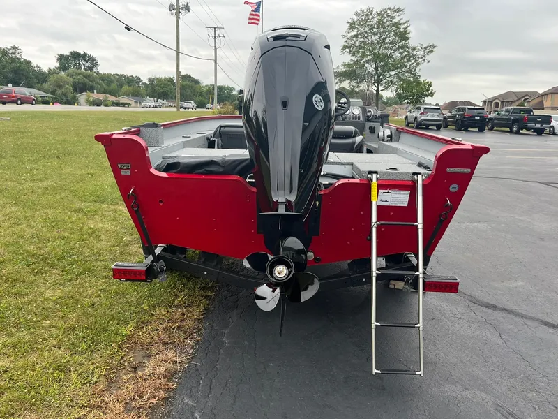Slide: The Image of 2025 Lund 1675 Adventure SS boat, red exterior, rear view with motor and ladder. - 2