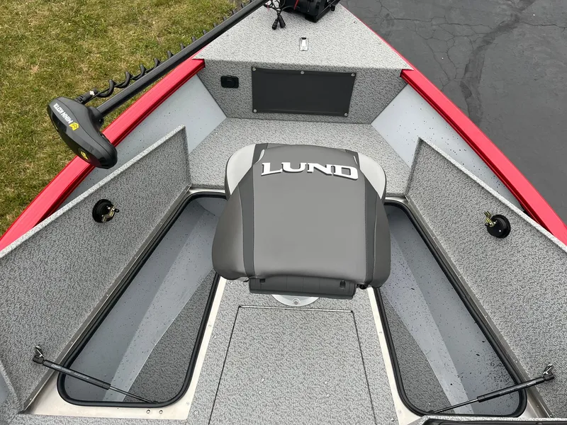 Slide: The Image of 2025 Lund 1675 Adventure SS boat interior with gray seating and red accents. - 9