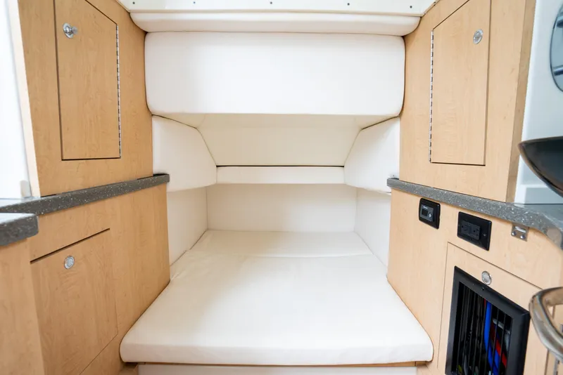 Slide: The Image of Interior cabin of 2018 Hydra-Sports 4200 Siesta with cushioned seating and wooden cabinetry. - 37