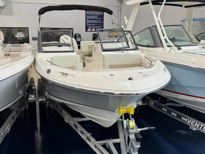 Slide: The Image of 2025 Boston Whaler 210 Vantage boat on trailer in showroom. - 2