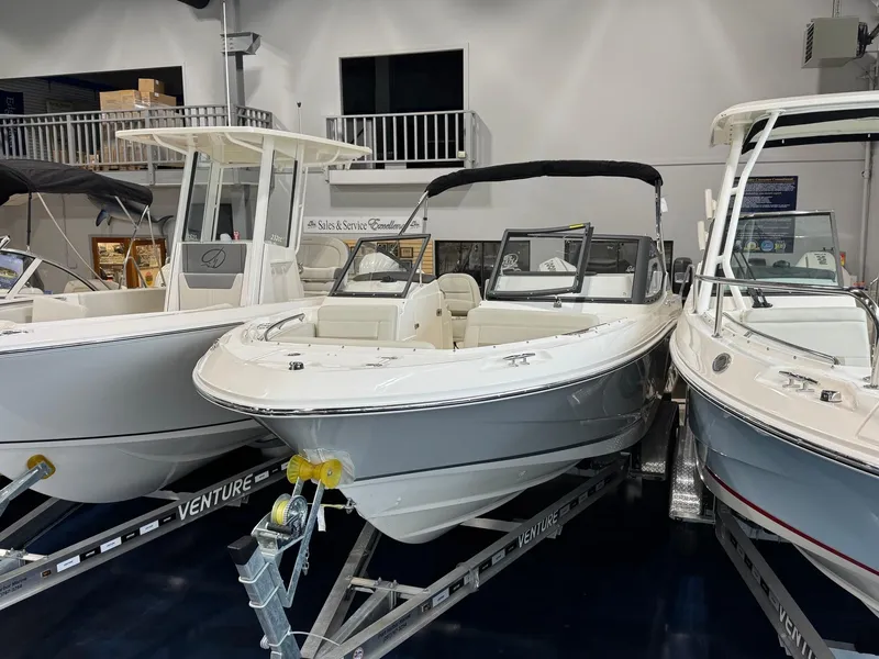 Slide: The Image of 2025 Boston Whaler 210 Vantage boat displayed in showroom on trailer. - 4