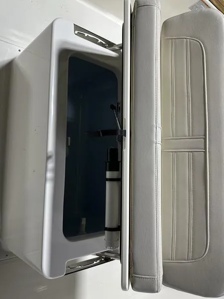 Slide: The Image of 2025 Boston Whaler 190 Montauk boat storage compartment with cushioned seat. - 12