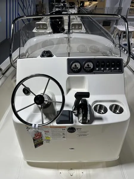 Slide: The Image of 2025 Boston Whaler 190 Montauk boat console with steering wheel and controls. - 13