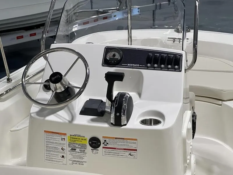 Slide: The Image of 2025 Boston Whaler 170 Montauk boat console with steering wheel and controls. - 5