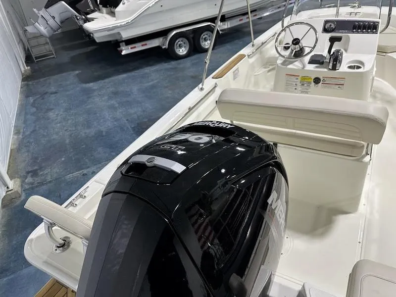 Slide: The Image of 2025 Boston Whaler 170 Montauk boat interior with Mercury engine in showroom. - 6