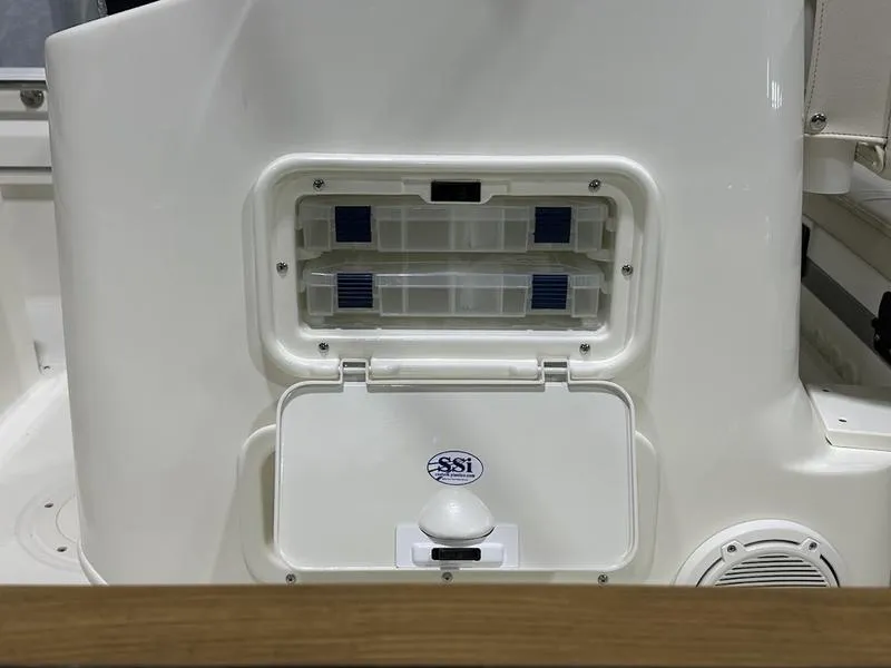Slide: The Image of 2025 Boston Whaler 170 Montauk storage compartment with SSI logo, white interior. - 9