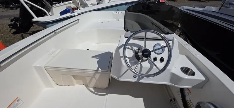 Slide: The Image of 2025 Boston Whaler 160 Super Sport boat interior with steering wheel and seating. - 4