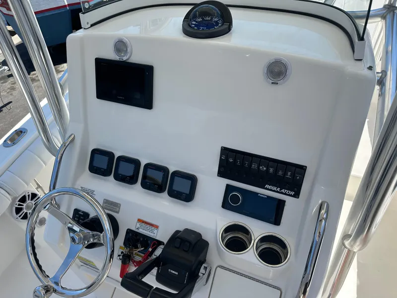 Slide: The Image of 2012 Regulator 24 FS boat dashboard with steering wheel, gauges, and controls. - 3