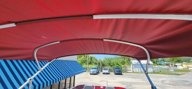 Slide: The Image of 2024 Bennington 20 SVF boat with red canopy and blue-striped awning in background. - 29