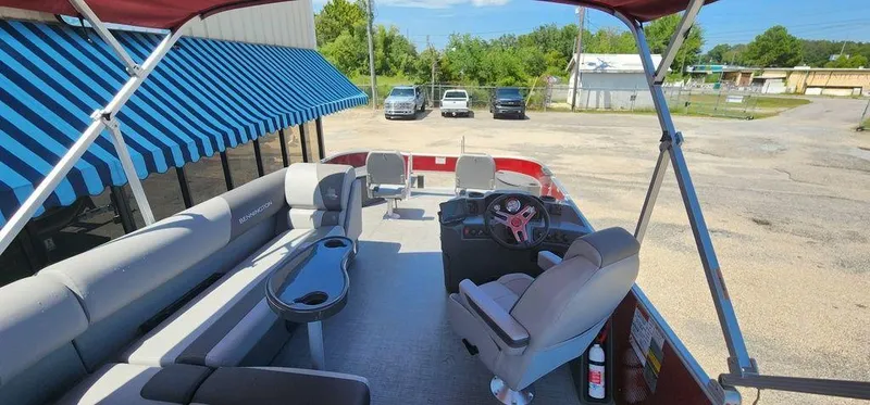 Slide: The Image of 2024 Bennington 20 SVF pontoon boat with spacious seating and canopy in a parking lot. - 30
